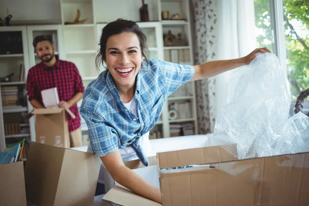 A person happily unpacking in a new kitchen.