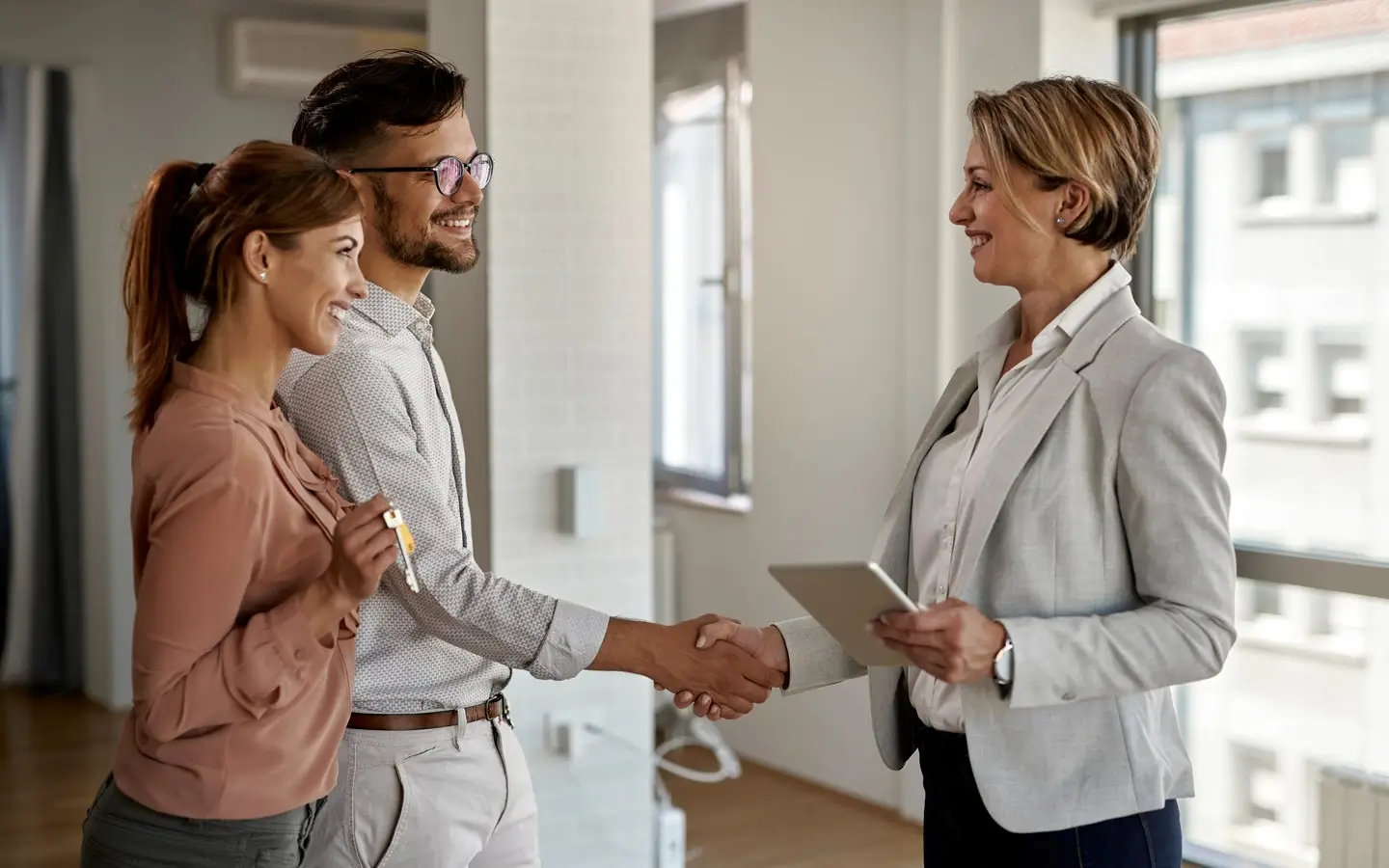 A professional mover warmly shaking a client's hand.